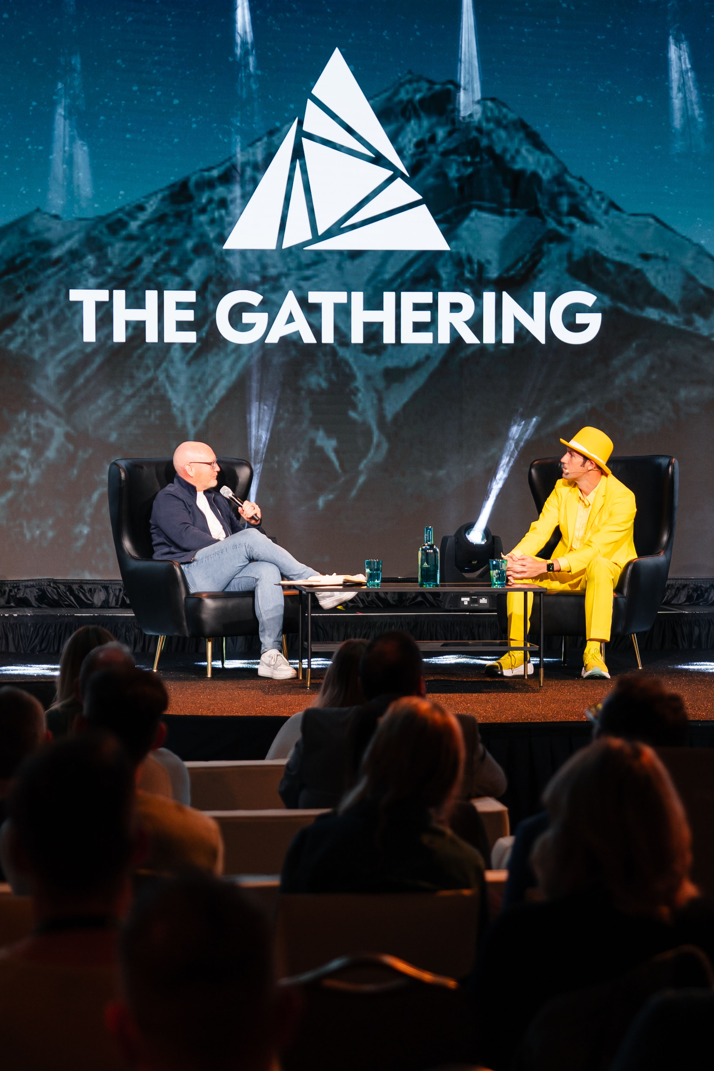 Two speakers conversing on stage under the gathering logo